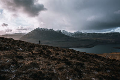 Scenic view of lake by mountains against sky