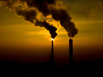 Power plant emissions seen above the city during sunrise. environmental pollution. factory pipe 