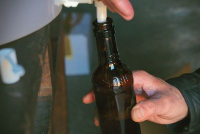 Cropped image of hand holding beer bottle