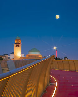 Illuminated building against blue sky at night