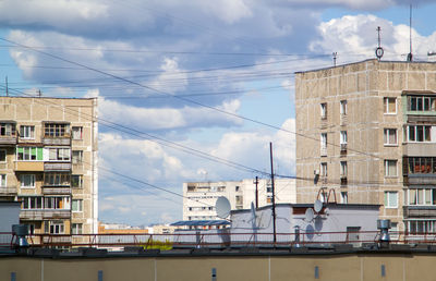 Buildings in city against cloudy sky