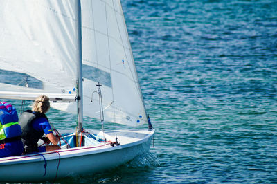 Woman sailing sailboat in sea