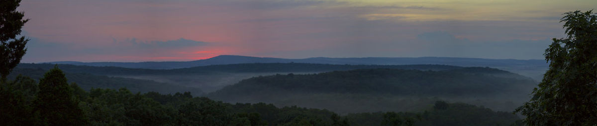 Scenic view of mountains against sky at sunset
