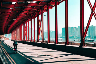 Man walking on bridge in city