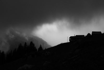 Silhouette of building against cloudy sky