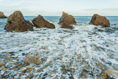 Rocks on beach against sky