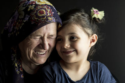 Portrait of happy friends against black background