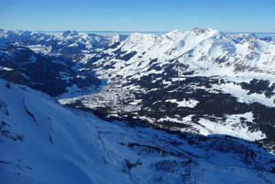 Scenic view of snowcapped mountains against blue sky