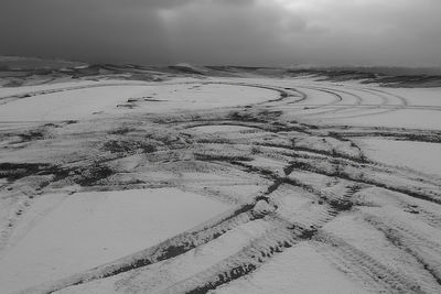 Tire trails in snow on the hill in winter
