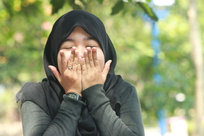 Portrait of teenage girl covering face