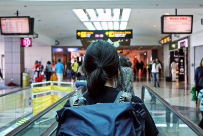 Rear view of woman standing at airport