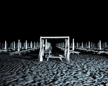 Empty chairs on beach against clear sky