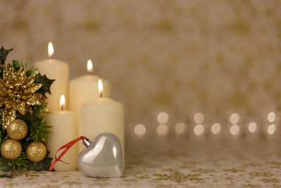 Close-up of christmas decorations with candles on table