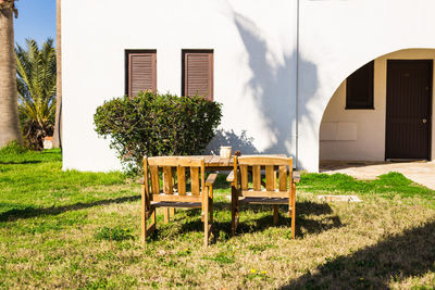 Chairs and table in lawn against building