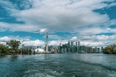 Scenic view of river by buildings against sky