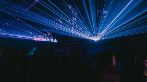 Crowd at illuminated music concert at night