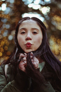 Portrait of young woman puckering outdoors 