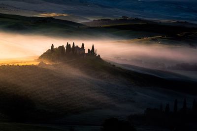 Scenic view of farms in foggy weather