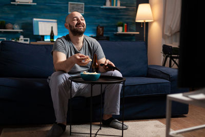 Smiling man watching movie at home