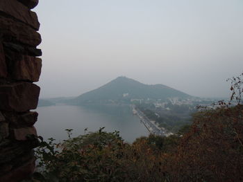 Scenic view of fateh sagar lake by mountain against sky seen from moti magri