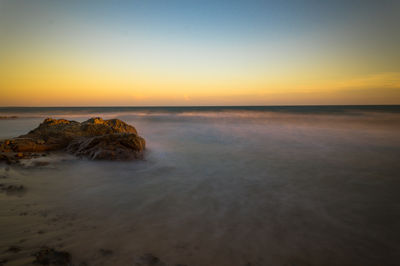 Scenic view of sea against clear sky at sunset