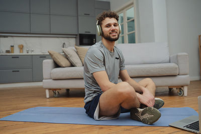Portrait of young man sitting on sofa at home