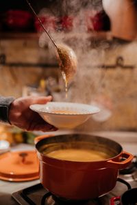 Cropped hand of man preparing food in kitchen