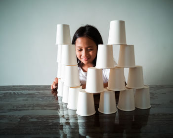 Smiling girl stacking glasses