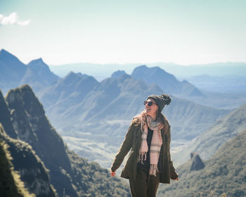 Portrait of woman standing against mountain