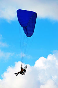 Person motor paragliding against sky