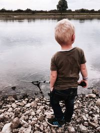 Rear view of boy standing on rock