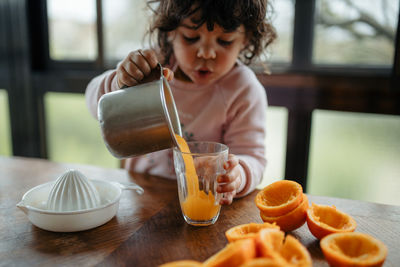 Cute girl holding juice at home