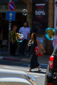 Children playing with bubbles in city