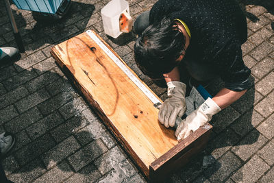 High angle view of boy working on wood