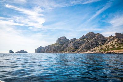 Scenic view of sea and mountains against sky