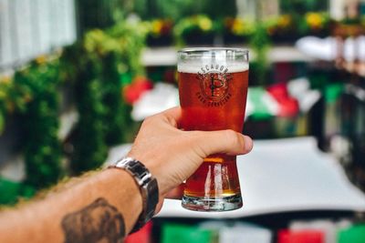 Close-up of hand holding beer glass