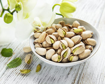 Bowl with pistachios on a wooden table