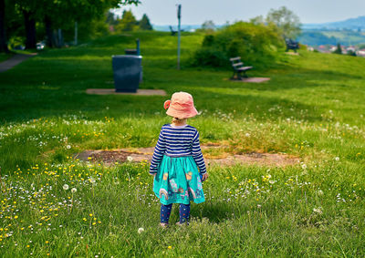 Rear view of girl standing on grassy land