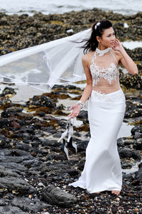 Full length of bride standing at beach