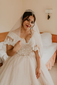 Portrait of bride standing against wall