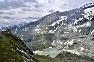 Scenic view of glacier lake and snowcapped mountains against sky