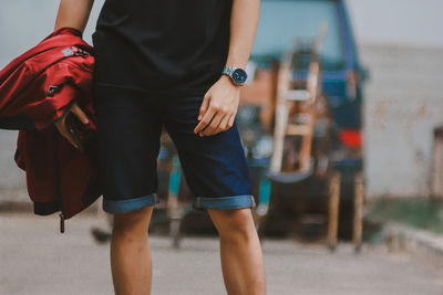 Midsection of man holding umbrella walking on bus