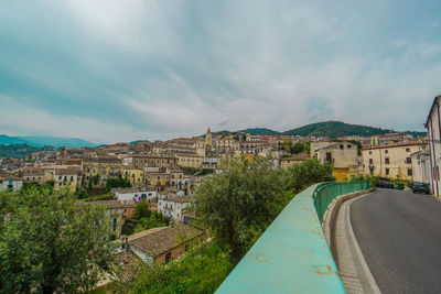 Panoramic shot of townscape by road against sky