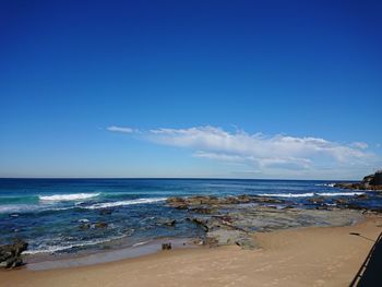 Scenic view of beach against blue sky