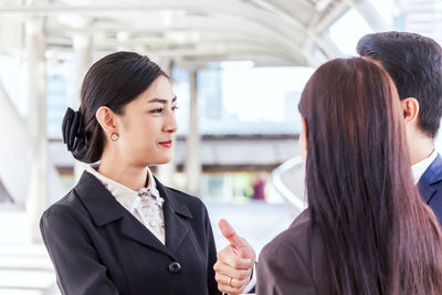 Colleagues discussing while standing in office