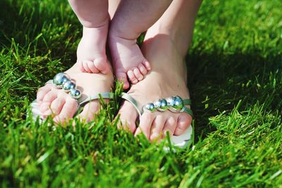 Low section of mother and baby on field