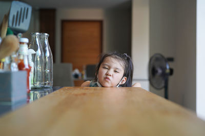 Portrait of girl on table at home