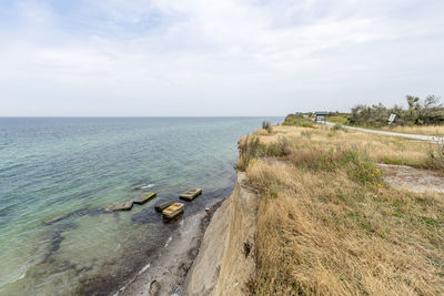 German baltic sea coast with sand dunes, grass, water and blue sky