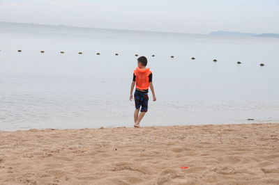 Rear view of man walking on beach