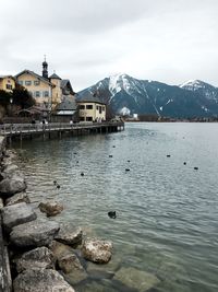 Scenic view of lake by snowcapped mountains against sky